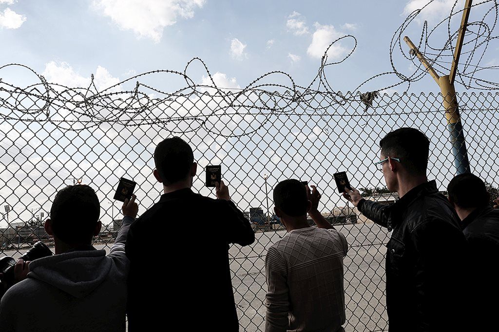 Beberapa pemuda  Palestina, Senin (20/11), menunggu sambil menunjukkan paspor mereka sebelum menyeberang ke Mesir. Pemerintah Mesir membuka kembali pintu perbatasan Rafah yang berbatasan langsung dengan Gaza menyusul rekonsiliasi Hamas dan Fatah. 