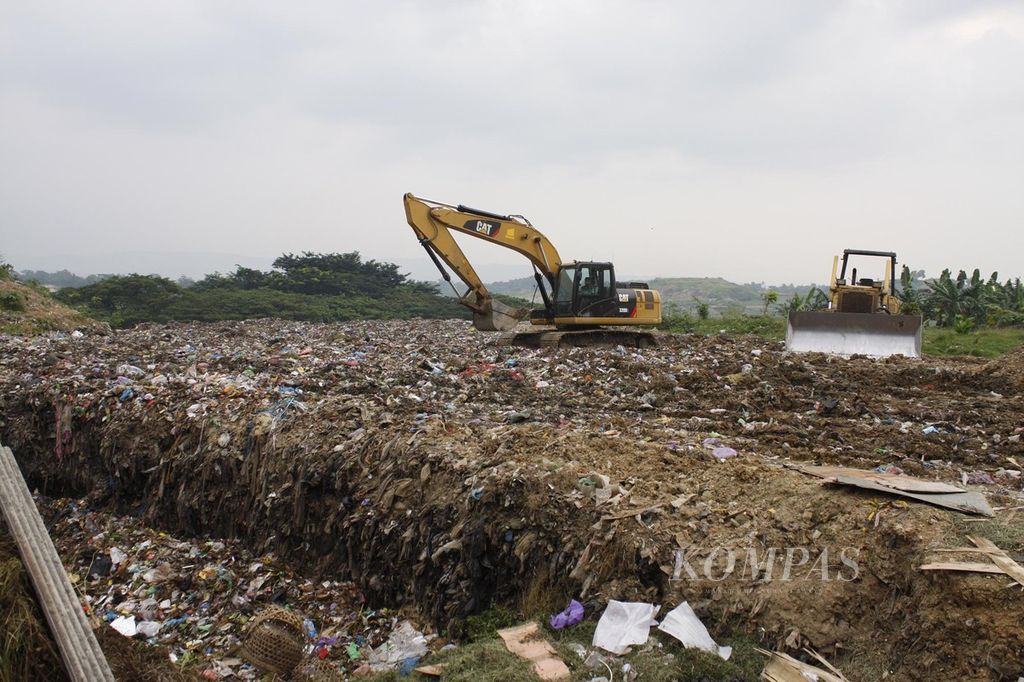 Alat berat dikerahkan untuk memadatkan dan mengelola tumpukan sampah di Tempat Pemrosesan Akhir Tritih Lor, Jeruk Legi, Cilacap, Jawa Tengah, Kamis (22/3/2018).