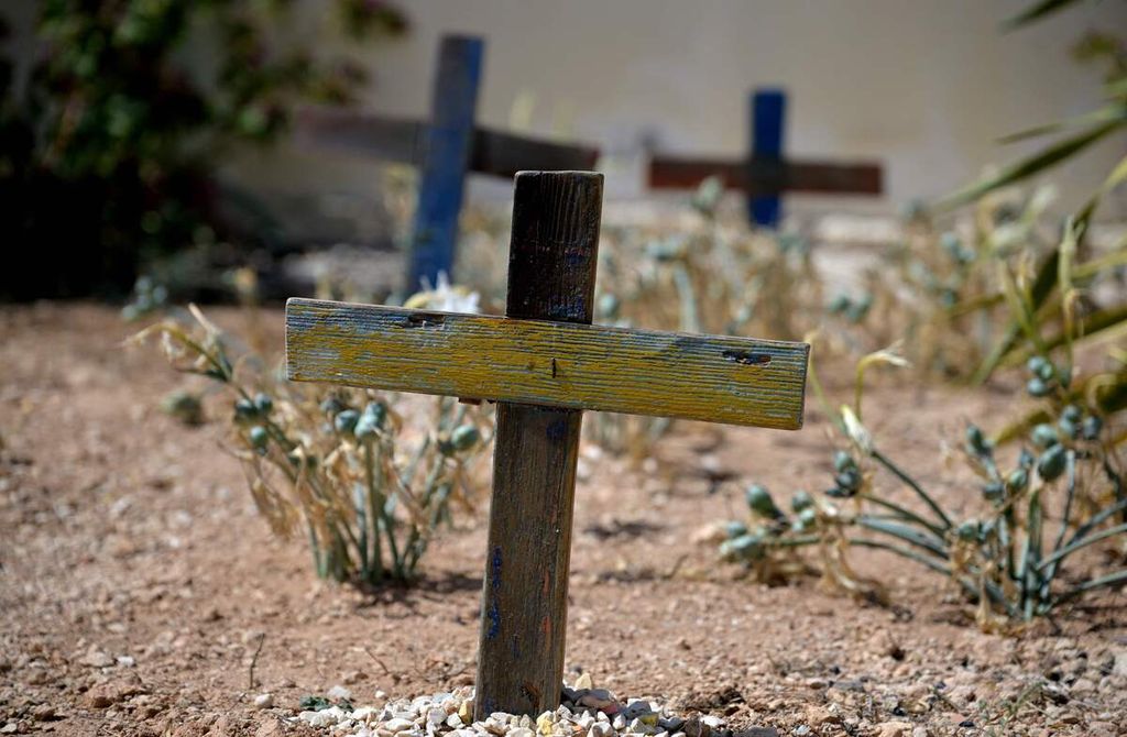 Nisan berbentuk salib yang terbuat dari kayu sisa perahu pengungsi yang digunakan saat melintasi Laut Tengah tampak di sebuah area pemakaman di Lampedusa. Foto diambil pada 25 September 2023. 