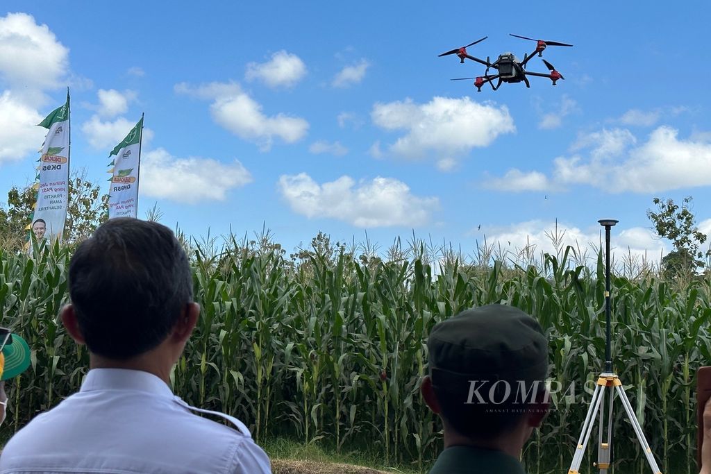 Para undangan peluncuran benih jagung bioteknologi dari Bayer, DEKALB DK95R, menyaksikan simulasi penyemprotan pestisida menggunakan <i>drone</i> di ladang jagung milik petani di Desa Banggo, Kecamatan Manggalewa, Kabupaten Dompu, Nusa Tenggara Barat, Rabu (26/7/2023). 