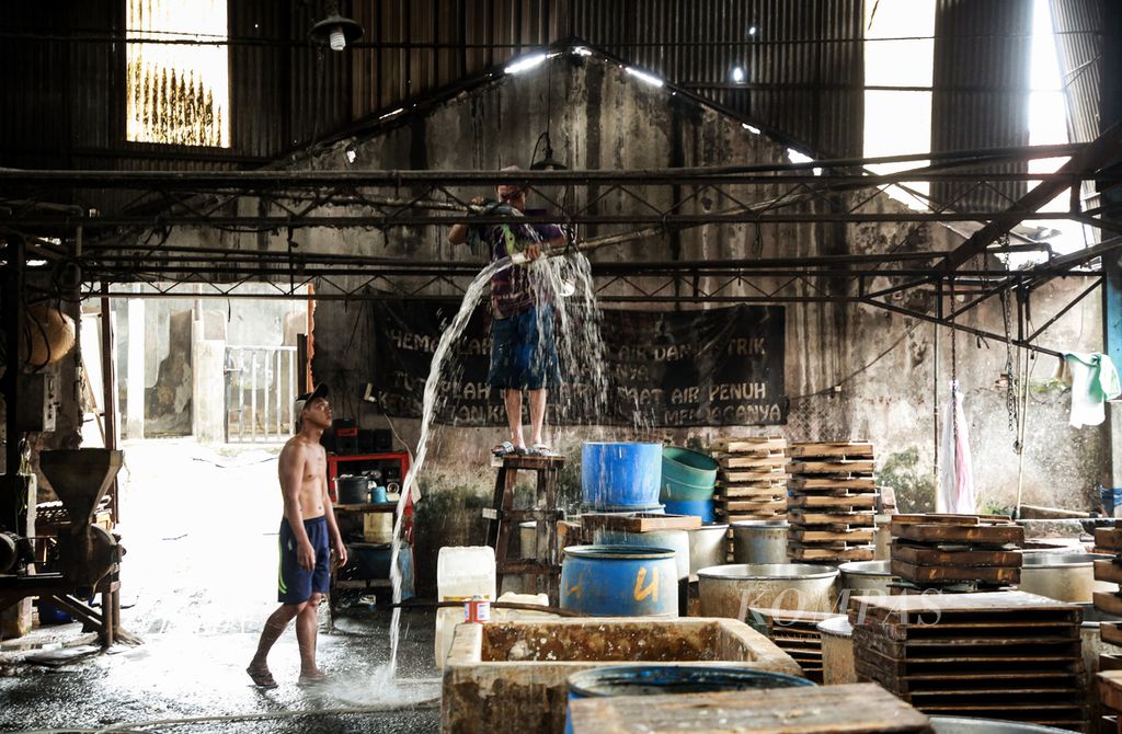 Para perajin tahu yang mogok produksi memperbaiki saluran air di tempat produksi tahu di kawasan Duren Tiga, Kecamatan Pancoran, Jakarta Selatan, Selasa (6/12/2022). Tempat produksi tahu yang dihuni oleh 40 orang perajin itu menghabiskan sekitar 1,3 ton kedelai impor setiap harinya.