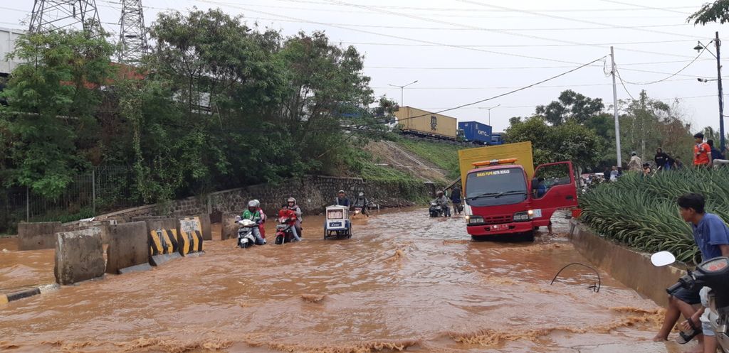 Sejumlah pengendara motor nekat menembus banjir yang terjadi di Jalan KH Noer Ali, Jakasampurna, Bekasi Barat, Kota Bekasi, Jawa Barat, Selasa (30/10/2018).