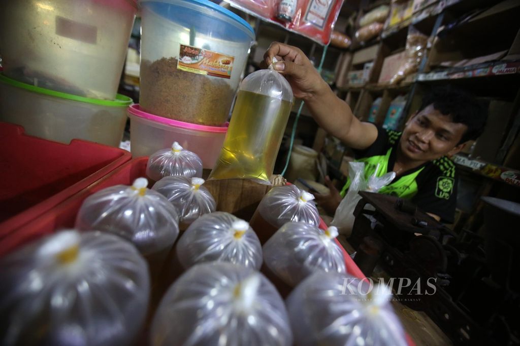 Seorang pedagang menjajakan minyak goreng curah kiloan di lapaknya di Pasar Kebayoran Lama, Jakarta, Senin (8/7/2024). Pemerintah melalui Kementerian Perdagangan tidak lagi mengatur harga eceran tertinggi minyak goreng curah dan mengeluarkan minyak itu dari program Minyak Goreng Rakyat.