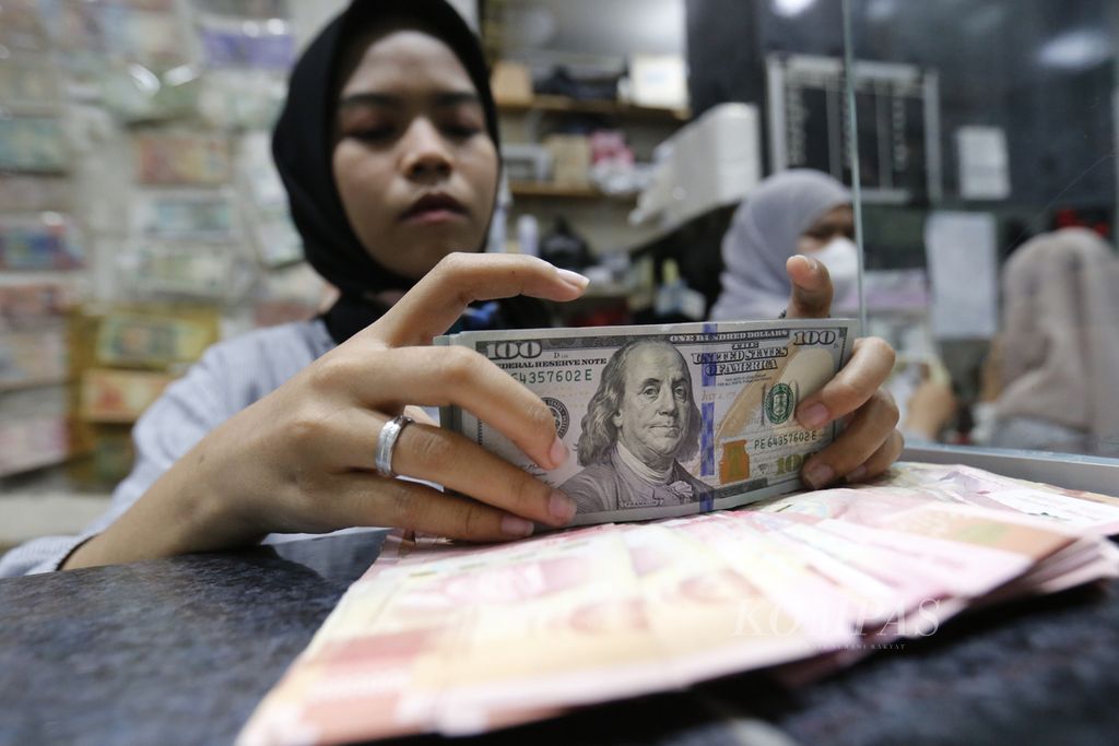 Pegawai perusahaan penukaran uang asing Valuta Artha Mas di ITC Kuningan, Jakarta, menghitung dan melihat kondisi lembaran uang dollar AS, Senin (7/8/2023).  
