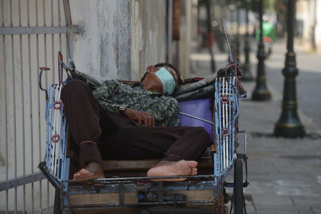 Pengemudi becak tertidur saat menunggu penumpang di kawasan Kota Lama, Kota Semarang, Jawa Tengah, Senin (20/4/2020). 