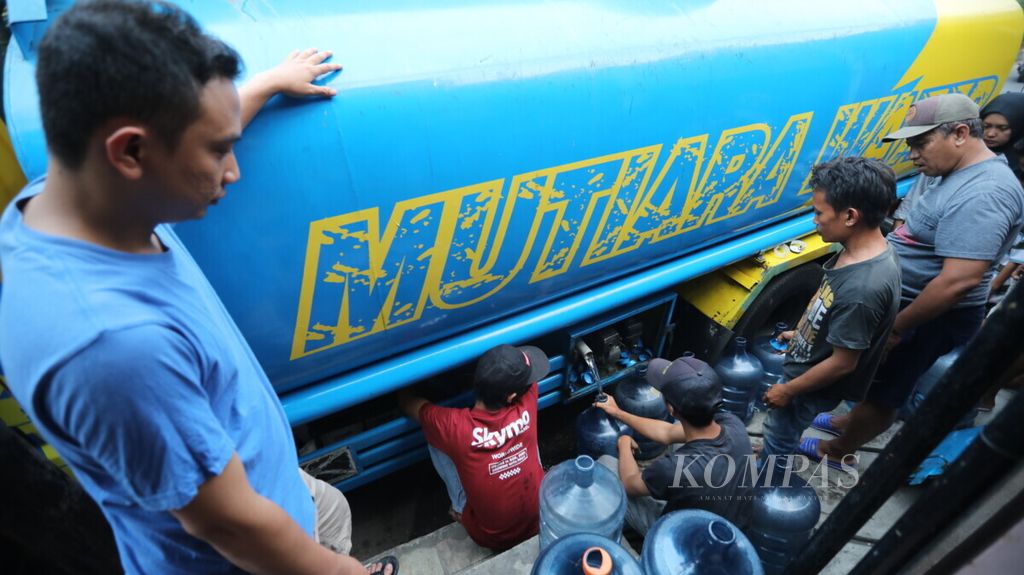 Antrean warga yang membeli air dari truk tangki di pangkalan air isi ulang di kawasan Kemandoran, Jakarta Pusat, Minggu (4/8/2019). 