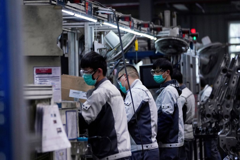 Sejumlah pekerja menggunakan masker bekerja di salah satu unit di perakitan mobil di pabrik Yanfeng Adient di Shanghai, China, 24 Februari 2020. (REUTERS/Aly Song)