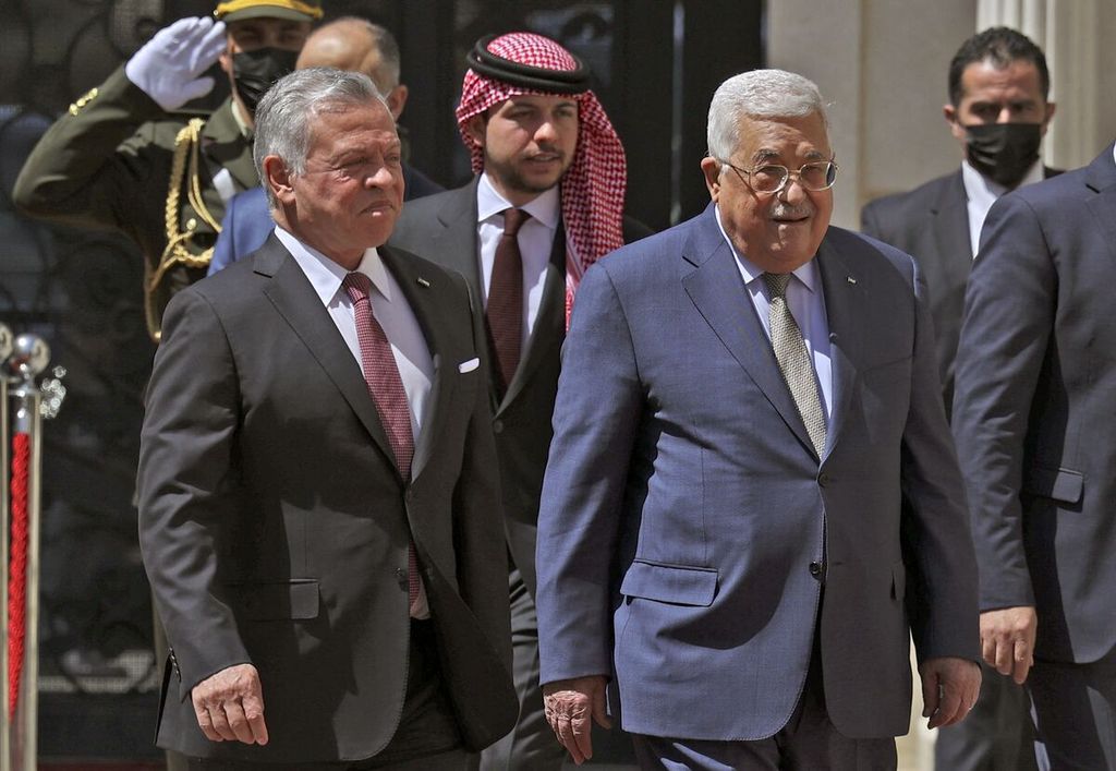Presiden Palestina Mahmoud Abbas (kanan) menyambut kedatangan Raja Jordania Abdullah II (kiri), yang didampingi Putra Mahkota Hussein (tengah), menjelang pertemuan mereka di Ramallah, wilayah pendudukan Tepi Barat, 28 Maret 2022. 