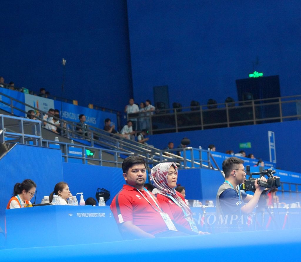 Pelatih bulu tangkis Indonesia, Nofi Tri Darma dan Herawati Soepandi, menyaksikan atlet Indonesia bertanding, Sabtu (5/8/2023), di Universiade Chengdu, China.