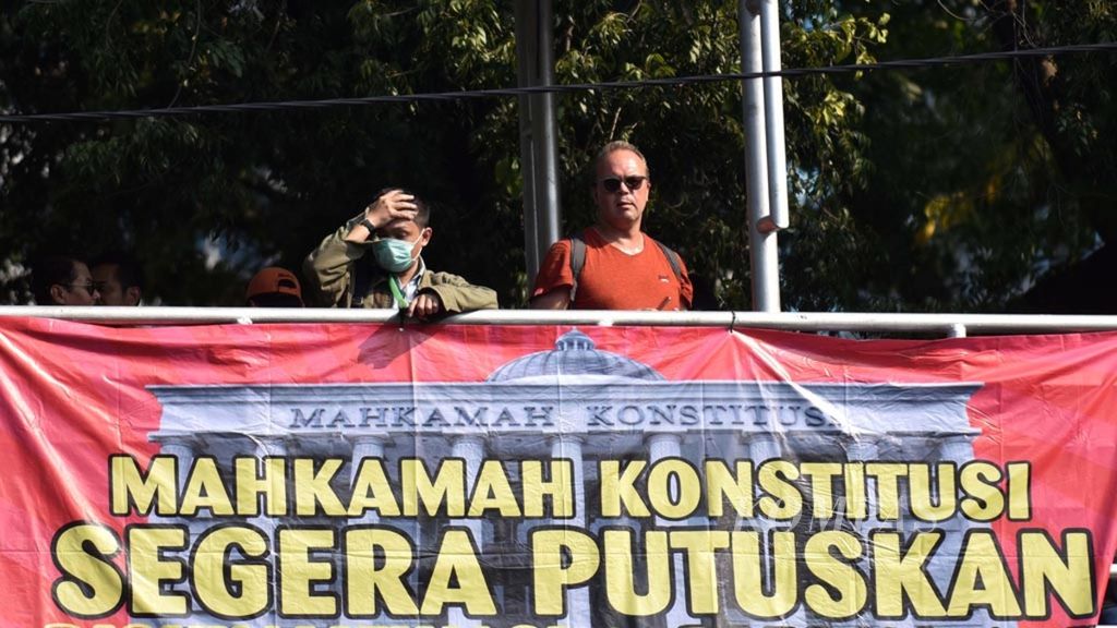 Warga menyaksikan unjuk rasa bertajuk Mengawal Mahkamah Konstitusi dari atas jembatan penyeberangan Patung Kuda, Jalan Merdeka Barat Jakarta, Rabu (26/6/2019). Pada Kamis (27/6/2019), MK dijadwalkan memutus sengketa hasil pemilihan umum Pilpres 2019.