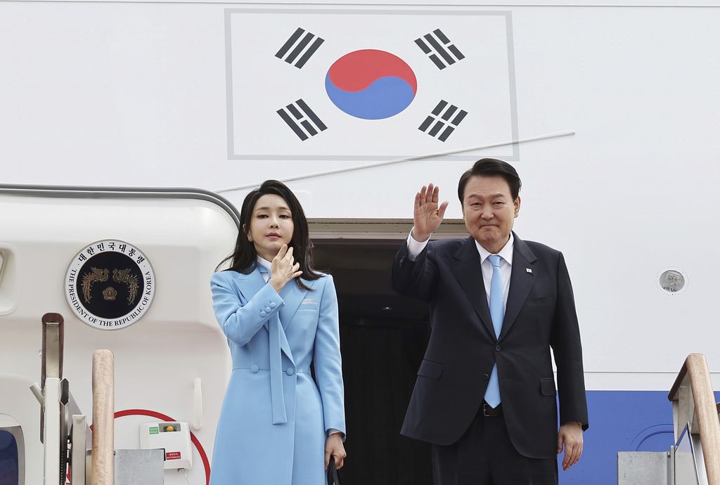 Presiden Korea Selatan Yoon Suk Yeol (kanan) dan istri, Kim Keon Hee, melambaikan tangan sebelum masuk ke dalam pesawat yang akan membawa mereka ke Washington DC, Amerika Serikat, 24 April 2023. 