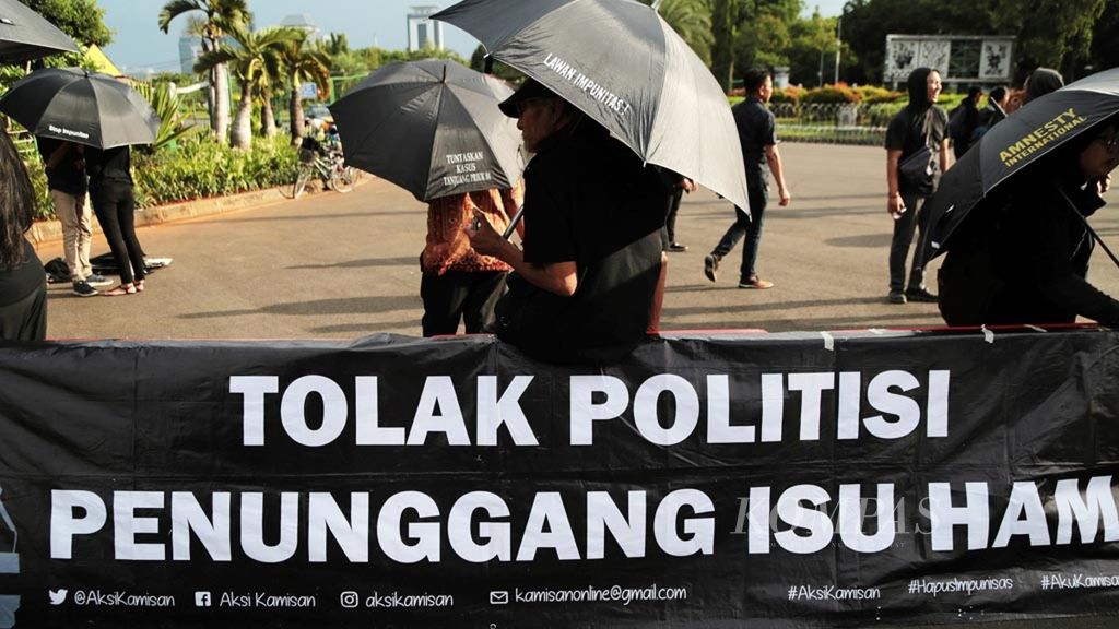 Para aktivis Aksi Kamisan kembali berkumpul menggelar aksi di depan Istana Merdeka, Jakarta, dengan mengangkat tema menuntut pemerintah menuntaskan sejumlah kasus pelanggaran Hak Asai Manusia (HAM) berat masa lalu, termasuk kasus Tragedi Semanggi I yang 20 tahun tidak terselesaikan, Kamis (15/11/2018). 