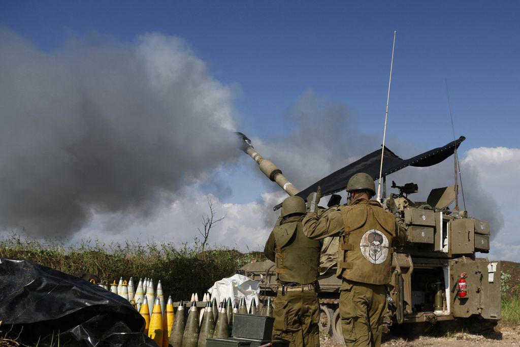 An Israeli soldier, wearing a patch on the back of his flack jacket indicating Lebanese Hezbollah leader Hassan Nasrallah as the target, stands in front of a self-propelled artillery howitzer. /i>in the Upper Galilee in northern Israel, when artillery units attacked southern Lebanon on January 4, 2024.