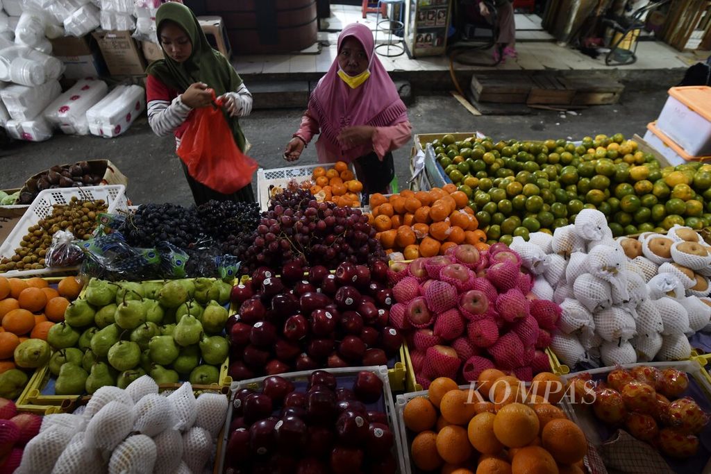 Pedagang menyiapkan buah pesanan pelanggan di Pasar Kebayoran Lama, Jakarta, Jumat (11/6/2021), Rencana pengenaan Pajak Pertambahan Nilai (PPN) pada bahan kebutuhan pokok, termasuk beras, jagung, daging, sayur, dan buah-buahan, oleh pemerintah menuai beragam reaksi di masyarakat. 