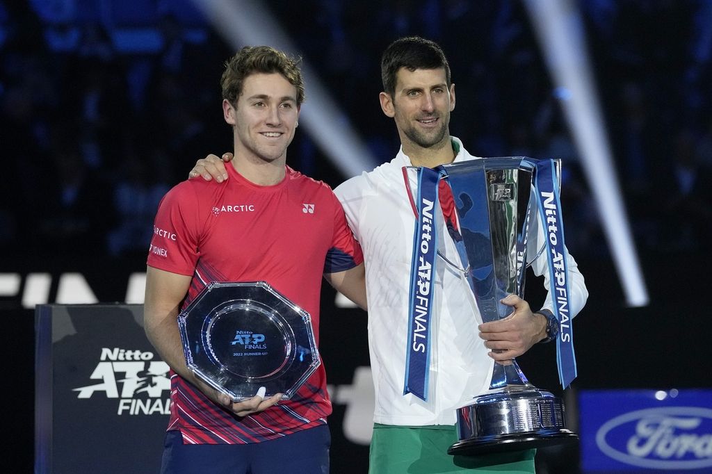 Petenis Serbia Novak Djokovic (kanan) dan petenis Norwegia Casper Ruud berpose dengan trofi yang mereka raih usai laga final turnamen Final ATP di Turin Italia, Minggu (20/11/2022). Djokovic menjadi juara setelah menang dengan skor 7-5, 6-3. 