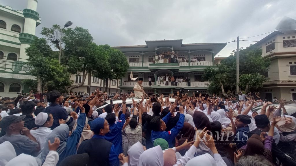 Calon presiden nomor urut 2, Prabowo Subianto, membagikan kaus gratis saat berkampanye di Pesantren Cipasung, Tasikmalaya, Jawa Barat, Sabtu (2/12/2023).