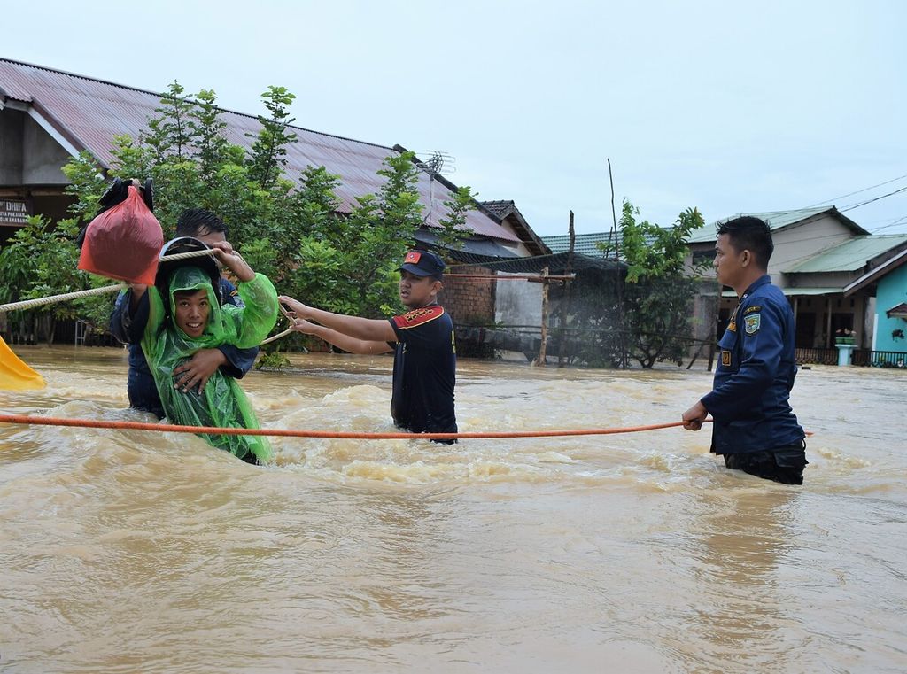 Officers from the Jambi City Fire and Rescue Service helped evacuate flood victims at the Kembar Lestari II Housing, Jambi City, Thursday (12/31/2020). Floods hit parts of the city after four hours of heavy rain.