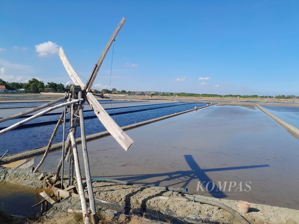 Baling-baling kincir angin berputar memompa air ke petak-petak ladang garam di Desa Aeng Sareh, Kecamatan Sampang, Kabupaten Sampang, Jawa Timur, Kamis (30/5/2024) sore.