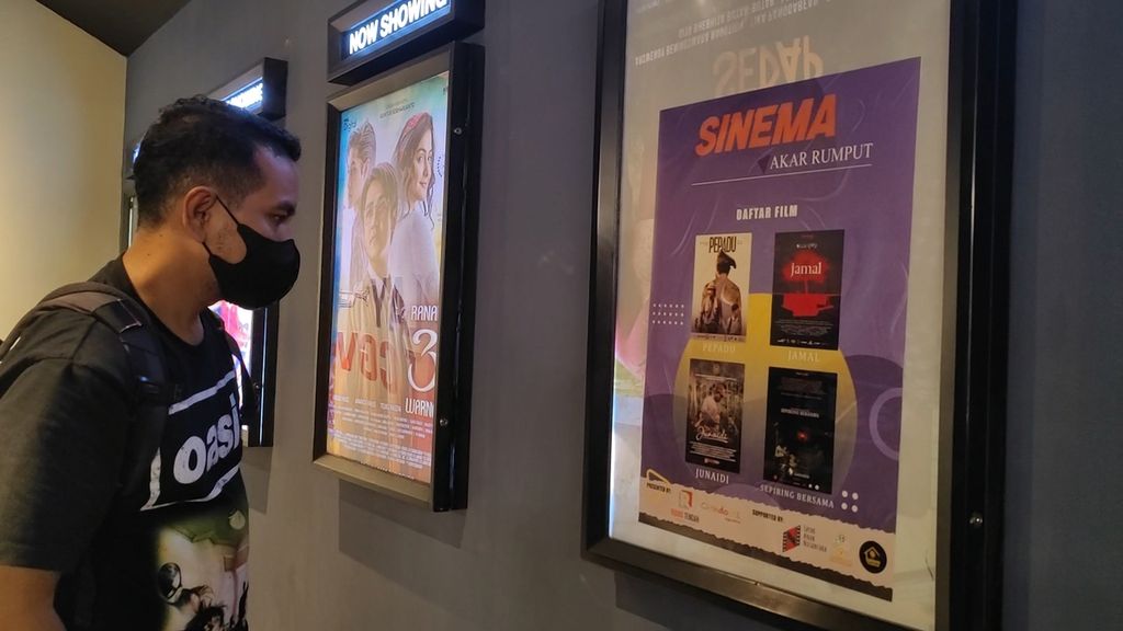 Seorang penonton melihat poster film pendek karya sineas asal Lombok yang diputar dalam program ”Sinema Akar Rumput” di Mataram, Nusa Tenggara Barat, Selasa (5/7/2022).