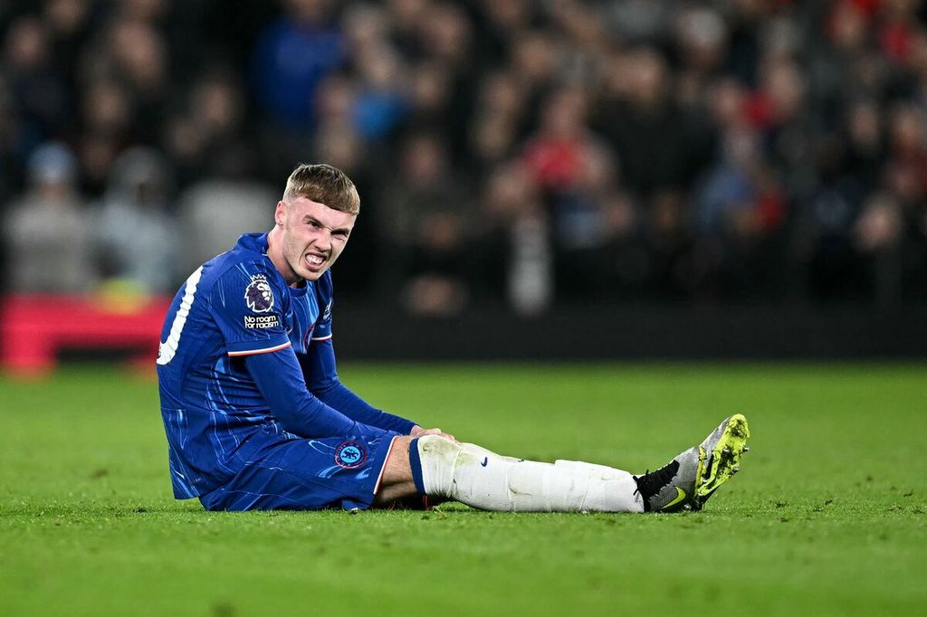 Gelandang Chelsea, Cole Palmer, meringis kesakitan setelah mengalami cedera saat menghadapi Manchester United pada laga Liga Inggris di Stadion Old Trafford, Manchester, 3 November 2024. Palmer diragukan tampil saat Chelsea menjamu Arsenal, Minggu (10/11/2024).