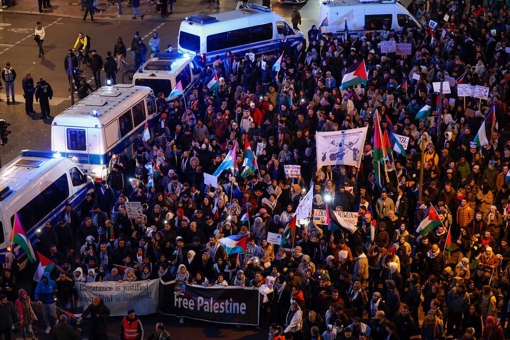 Pengunjuk rasa berpawai dalam aksi mendukung warga Palestina dengan slogan Bebaskan Palestina melewati jalan yang diblokir oleh mobil polisi di Berlin, Jerman, Sabtu (4/11/2023).  
