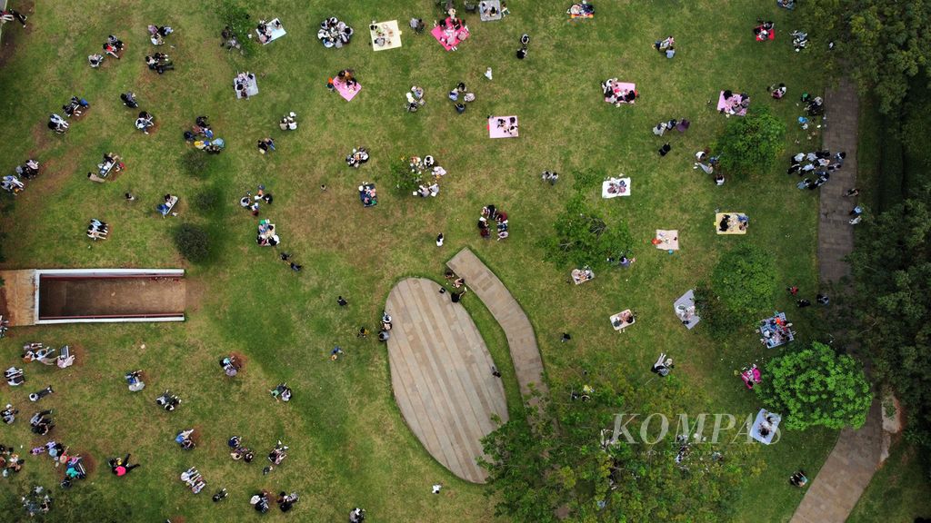 Warga bersantai sembari menikmati suasana sore di Hutan Kota Gelora Bung Karno, Jakarta, Minggu (25/6/2023). 