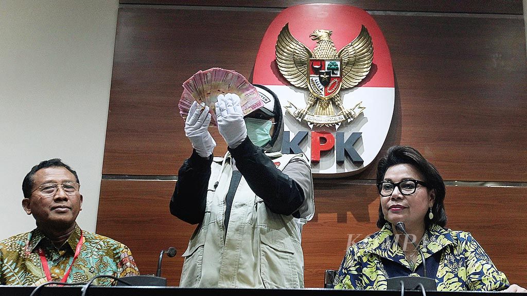 Penyidik Komisi Pemberantasan Korupsi (KPK) menunjukkan uang yang disita dari hasil operasi tangkap tangan dalam konferensi pers di Gedung KPK, Jakarta, Jumat (9/6). Dalam kesempatan itu, Jaksa Agung Muda Pengawasan (Jamwas) Widyo Pramono (kiri) dan  Wakil Ketua Komisi Pemberantasan Korupsi (KPK) Basaria Pandjaitan (kanan)  menjelaskan penangkapan oknum jaksa di Kejaksaan Tinggi Bengkulu terkait dugaan  suap.
