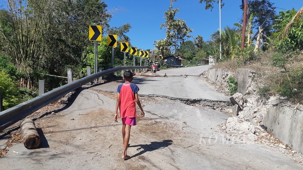 Seorang anak berjalan melewati jalan rusak yang menghubungkan Oebufu-Naimata di Kota Kupang, Nusa Tenggara Timur, Rabu (29/9/2021). Jalan yang ambruk akibat badai Seroja enam bulan lalu itu merupakan salah satu jalan alternatif menuju Bandar Udara El Tari.