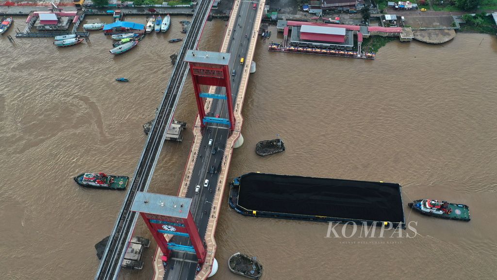 Kapal tongkang bermuatan batubara melintasi Jembatan Ampera di Kota Palembang, Sumatera Selatan, Sabtu (25/3/2023). Batubara merupakan salah satu komoditas ekspor andalan Indonesia yang turut menggeliatkan perekonomian daerah.