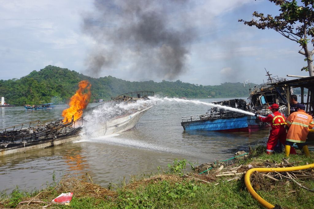 Petugas memadamkan api dengan <i>foam </i>di sekitar Dermaga Wijayapura, Cilacap, Jawa Tengah, Rabu (4/5/2022) pagi. Total ada 45 kapal yang terbakar sejak Selasa sore dan kerugian material Rp 130 miliar.