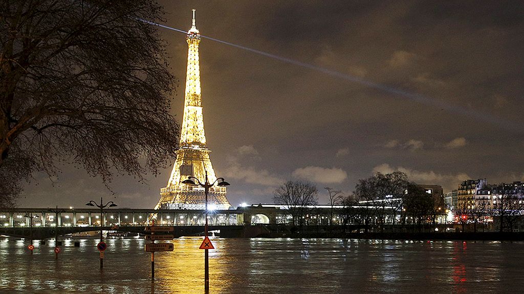 Tiang lampu jalan  dan papan penunjuk lalu lintas dengan latar belakang Menara Eiffel tampak terendam di dekat Sungai Seine, Paris, Perancis, Sabtu (27/1).  