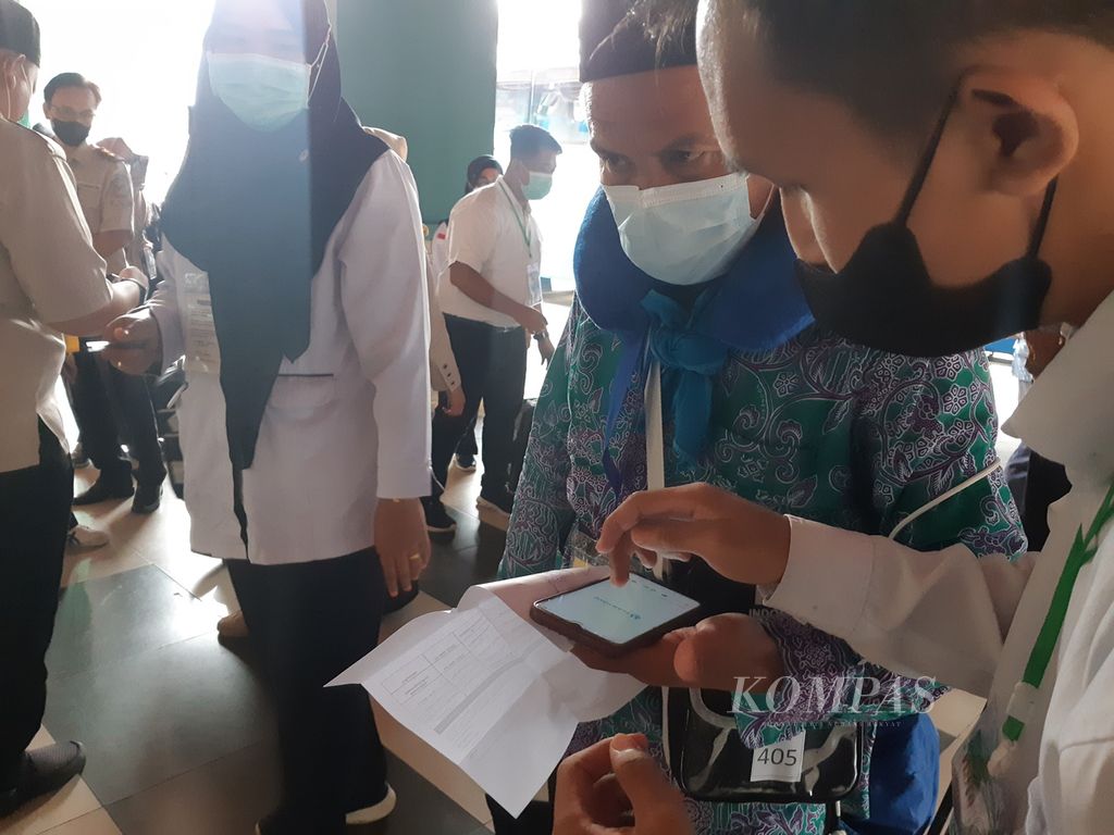 Petugas sedang memeriksa aplikasi Peduli Lindungi milik seorang anggota jemaah haji yang baru tiba di embarkasi Palembang, Sabtu (24/6/2022). 