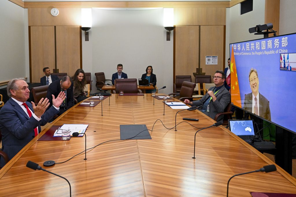 Menteri Perdagangan Australia Don Farrell (kiri) berbicara dengan Menteri Perdagangan China Wang Wentao (tampil di layar) secara daring dari Canberra, 6 Februari 2023. Ini dialog pertama menteri perdagangan kedua negara dalam tiga tahun belakangan. Hubungan Sydney-Beijing renggang sejak tahun 2017 dan mulai kembali mendekat sejak 2022.