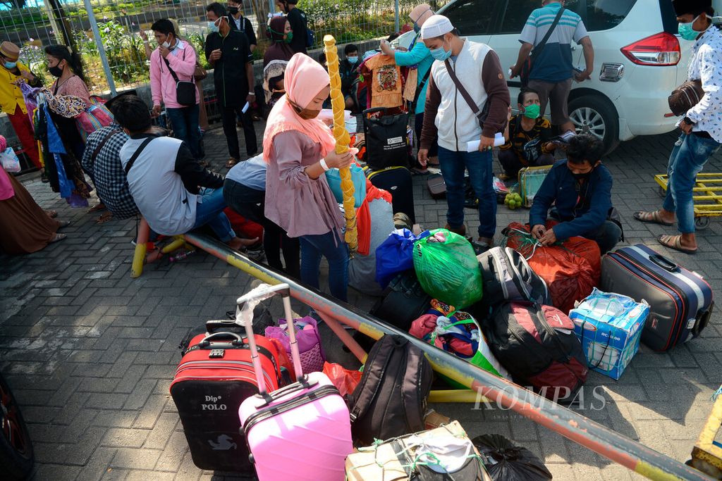 Pekerja migran yang tiba dari Malaysia saat menunggu angkutan untuk mengantarkan ke sejumlah daerah masing di Pelabuhan Tanjung Emas, Kota Semarang, Jawa Tengah, Jumat (15/5/2020). Sebagian dari mereka terpaksa pulang karena dihentikan dari pekerjaannya setelah pandemi Covid-19 melanda. 