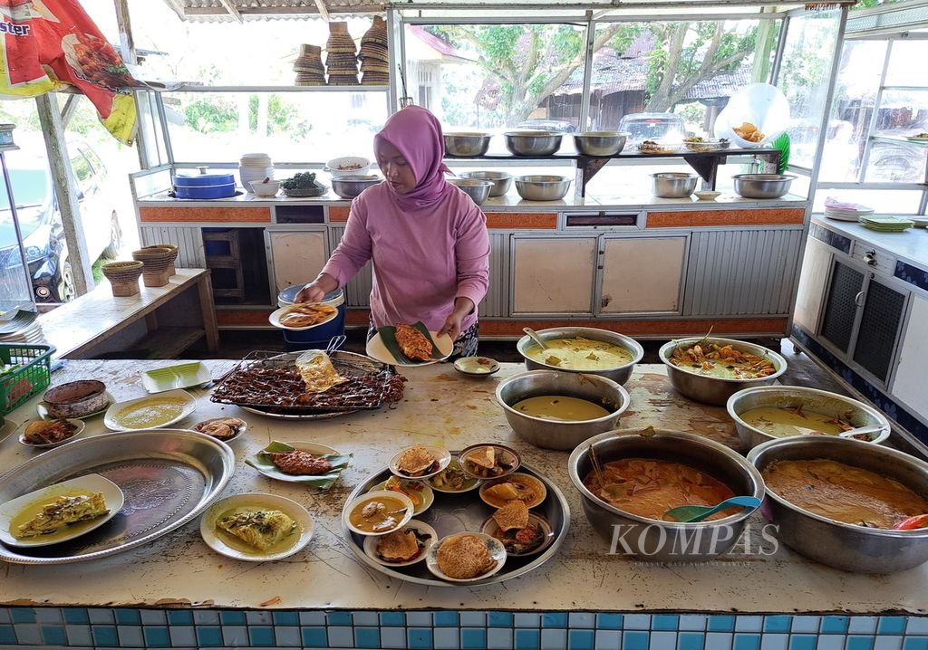Pemilik warung menyiapkan sejumlah menu untuk pengunjung di Lapau Nasi Mak Apuak, kawasan obyek wisata Pantai Pasir Jambak, Kelurahan Pasie Nan Tigo, Kecamatan Koto Tangah, Kota Padang, Sumatera Barat, Minggu (10/12/2023). 