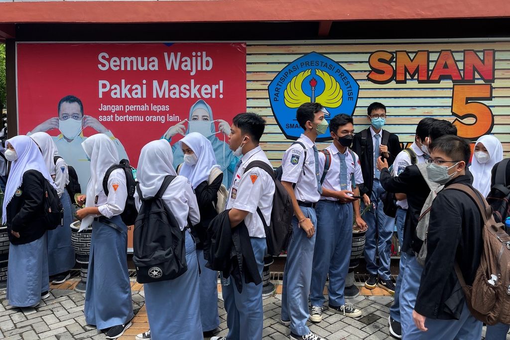 Siswa Sekolah Menengah Atas Negeri 5 Mataram, Nusa Tenggara Barat, mengenakan masker saat meninggalkan sekolah mereka, Senin (3/1/2021).