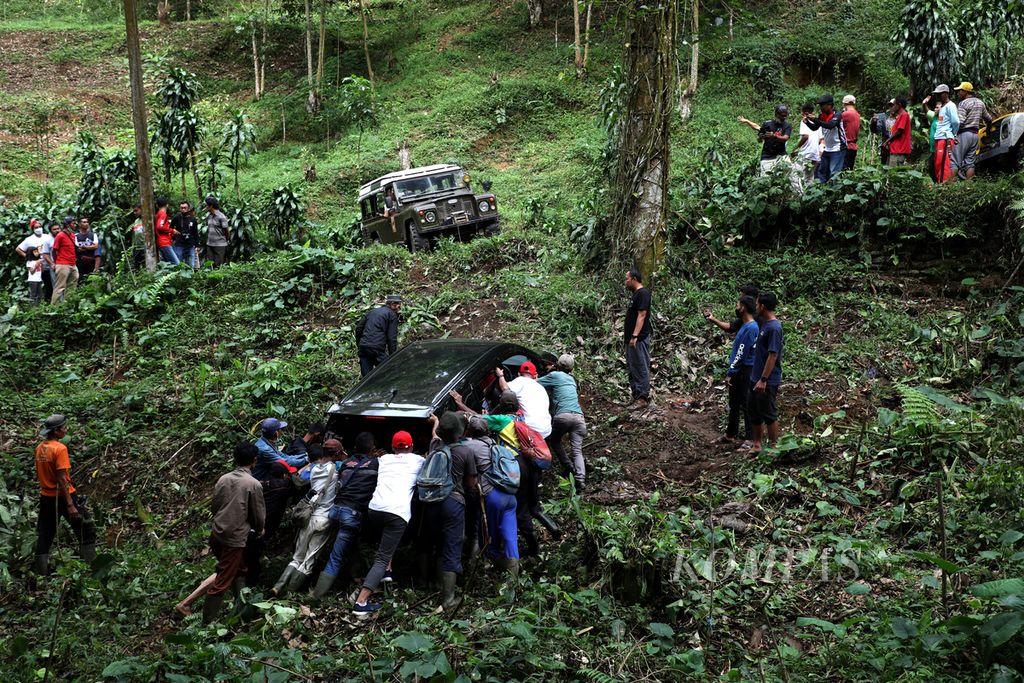 Evakuasi kendaraan yang terperosok ke jurang di kawasan Hutan Halimun Salak, Kecamatan Nanggung, Bogor, Jawa Barat, Sabtu (9/4/2022). Evakuasi dilakukan dengan menarik kendaraan dan dibantu warga yang mendorongnya. Kecelakaan disebabkan kendaraan tidak kuat menanjak di jalanan berbatu yang licin setelah hujan mengguyur kawasan tersebut. Tidak ada korban dalam peristiwa tersebut. 