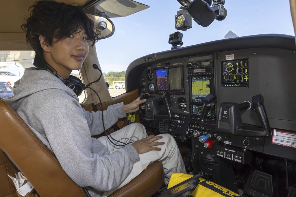 Pilot Amerika Serikat, Ethan Guo, berpose di dalam pesawat yang dikemudikannya di Geneva, Swiss, Selasa (6/8/2024), sebelum lepas landas dari Bandara Geneva untuk coba memecahkan rekor dunia penerbangan solo ke tujuh benua. 