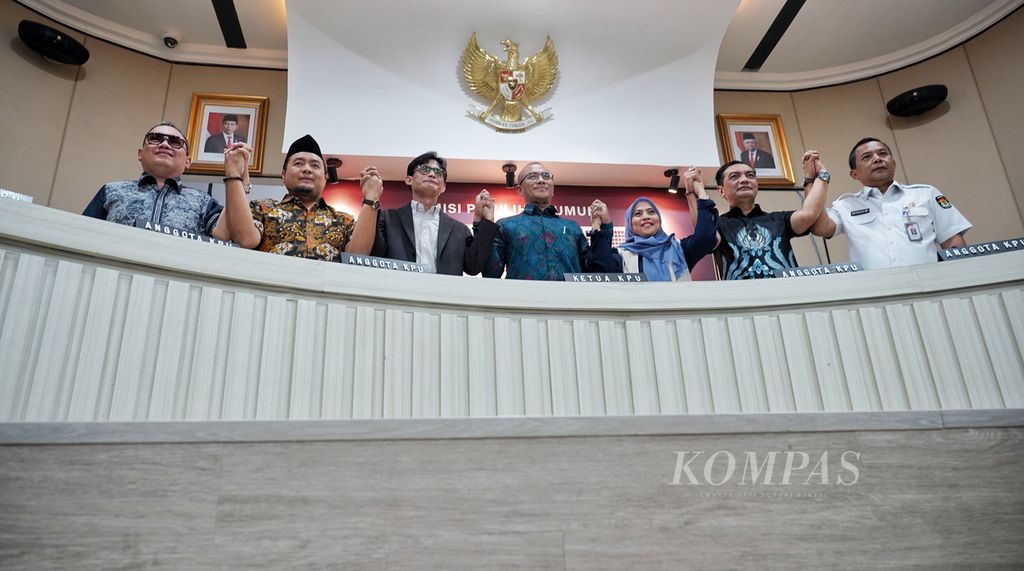 Ketua Komisi KPU Hasyim Asy’ari (tengah) bersama para komisioner KPU lainnya berdiri dan bergandengan tangan seusai konferensi pers persiapan menjelang Debat Calon Wakil Presiden Pemilu 2024 di Media Center Kantor KPU, Jakarta, Kamis (21/12/2023). 