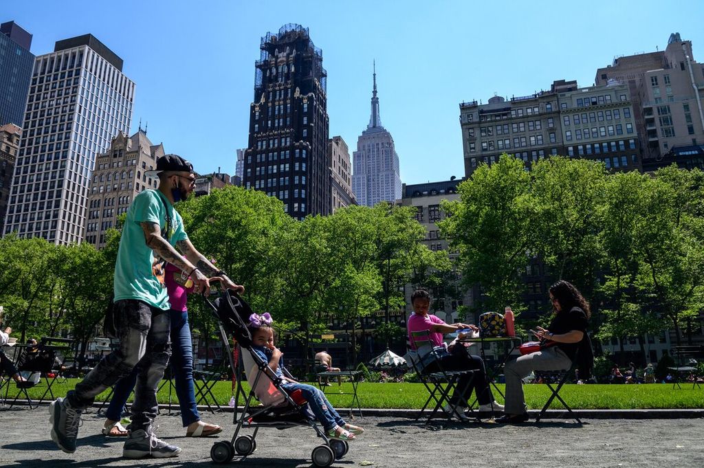 Warga menikmati sinar matahari di Bryant Park yang berada di tengah kota Manhattan, New York, Amerika Serikat, Senin (17/5/2021). Pemulihan ekonomi AS dibayangi tekanan global sebagai akibat dari perang Rusia-Ukraina. 