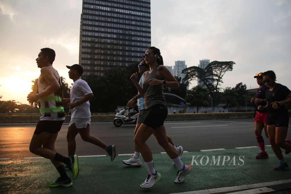 Warga berlari di Jalan Jenderal Sudirman, Jakarta, Rabu (22/3/2023). Libur Hari Raya Nyepi yang bertepatan dengan sehari menjelang puasa Ramadhan dimanfaatkan masyarakat untuk olahraga.  
