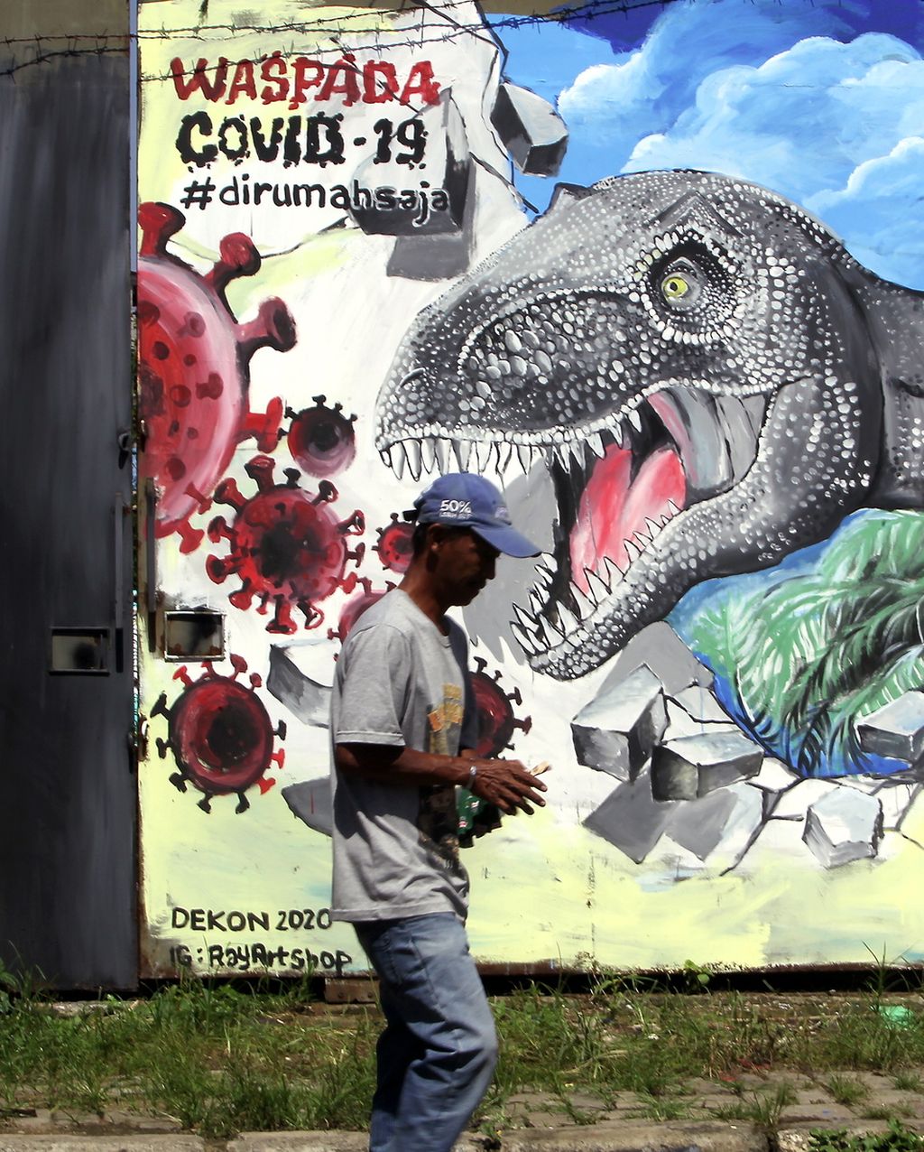 Warga melintas di depan mural bertema waspada Covid-19 di daerah Depok, Jawa Barat, Selasa (31/3/2020).
