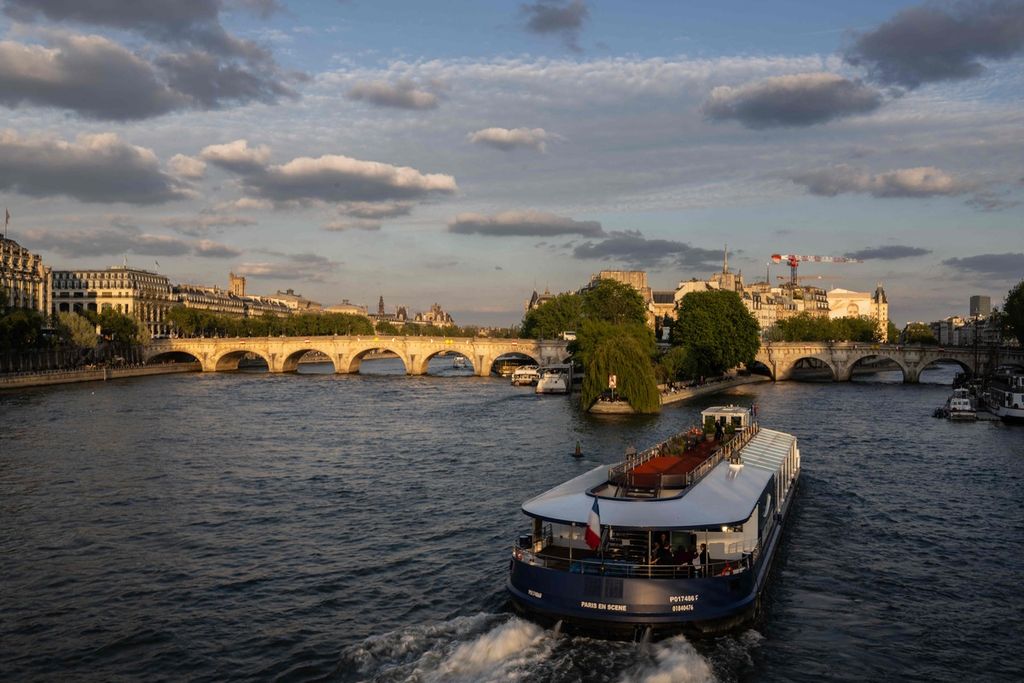 Sebuah perahu tengah menyusuri Sungai Seine di area dekat Pont Neuf di Paris saat senja, Selasa (23/4/2024). 