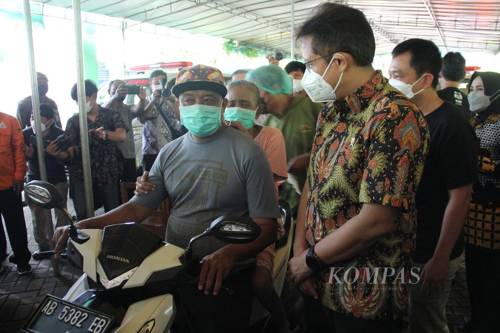 Menteri Kesehatan Budi Gunadi Sadikin berbincang dengan warga lanjut usia yang akan mengikuti vaksinasi Covid-19 di atas sepeda motor, Jumat (21/1/2022), di Desa Sumbermulyo, Kabupaten Bantul, DI Yogyakarta.