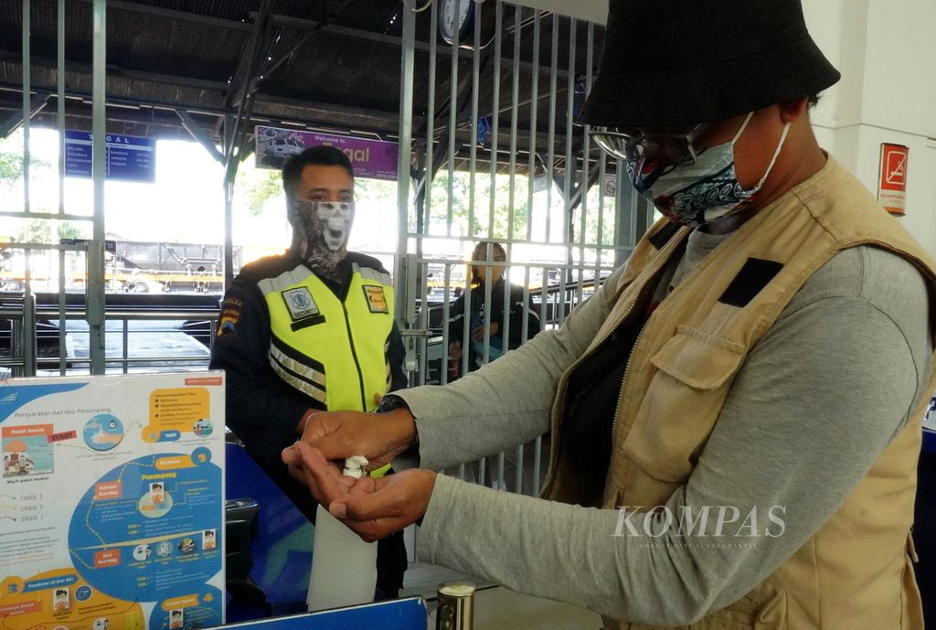 Pengunjung membersihkan tangan sebelum masuk ke peron Stasiun Tegal, Jawa Tengah, pada Juni 2020.
