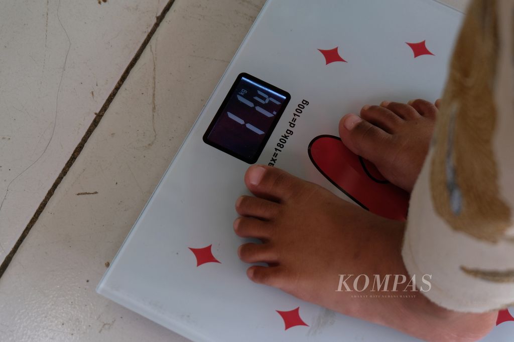 Seorang anak dengan <i>stunting</i> atau tengkes ditimbang berat badannya di RW 009 Kelurahan Cakung Barat, Kecamatan Cakung, Jakarta Timur, Sabtu (8/4/2023). 