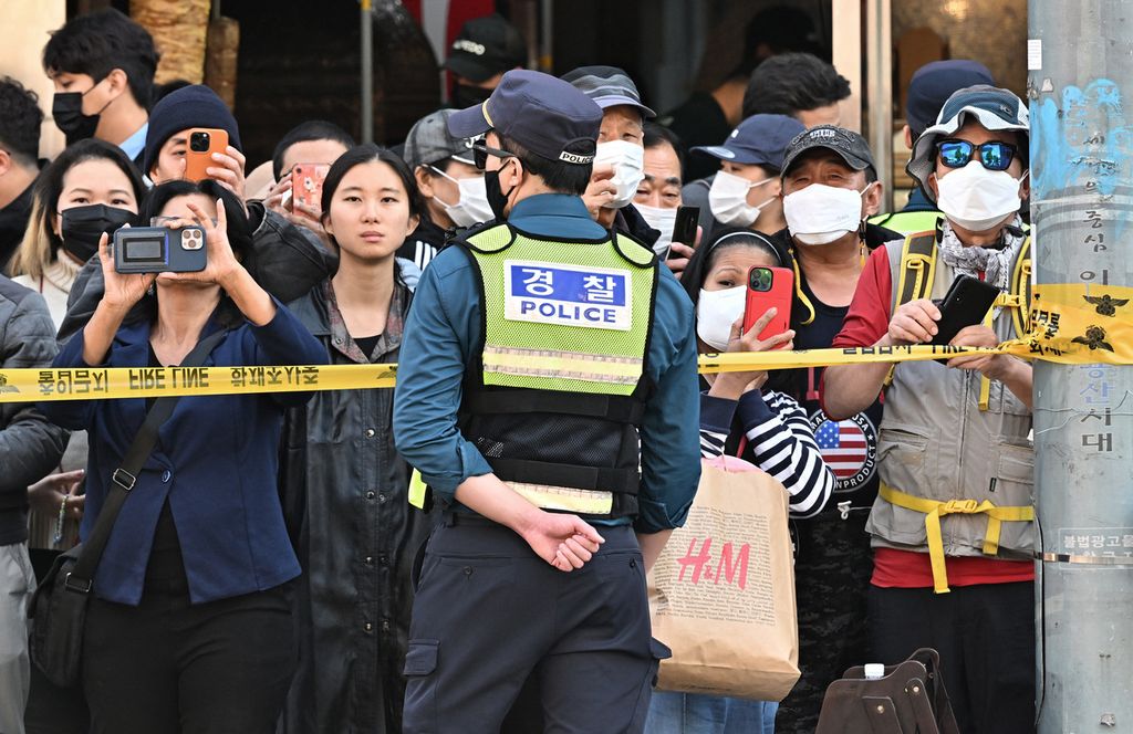 Orang-orang melihat lokasi insiden pesta Halloween di Distrik Itaewon, Seoul, Korea Selatan, Minggu (30/10/2022). Lebih dari 150 orang tewas dan lebih banyak lagi orang terluka dalam acara Halloween yang penuh sesak di pusat kota Seoul, Sabtu (29/10) malam. 