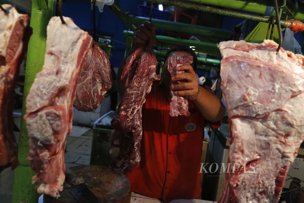 Pedagang daging sapi sedang melayani permintaan pembeli di Pasar Jatinegara, Jakarta Timur, Minggu (9/10/2022).
