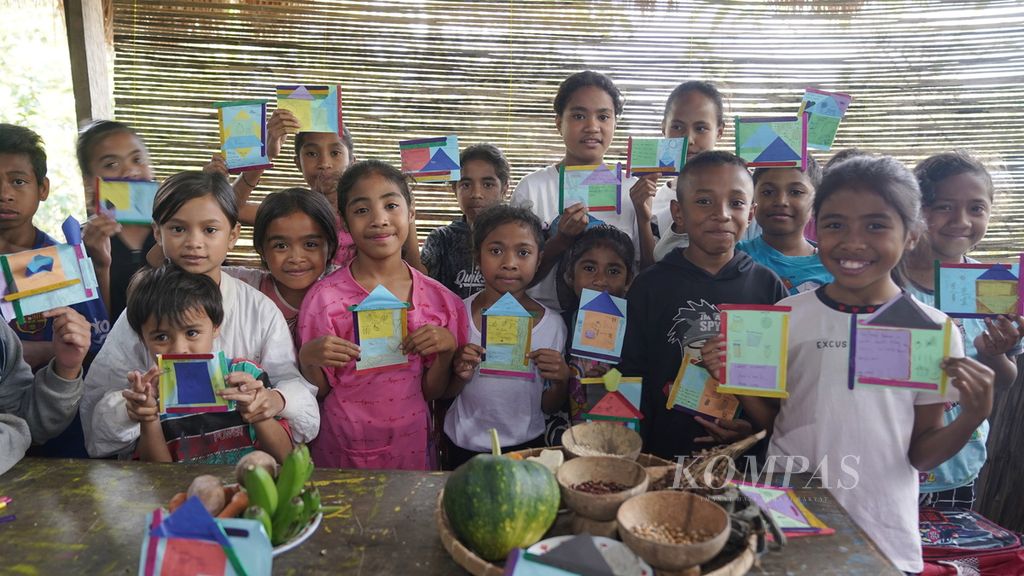 Anak-anak berpose dengan jawaban di kertas soal pengenalan makanan lokal di Lakoat.Kujawas di Desa Taifob, Kecamatan Mollo Utara, Kabupaten Timor Tengah Selatan, NTT, Senin (7/8/2023). 