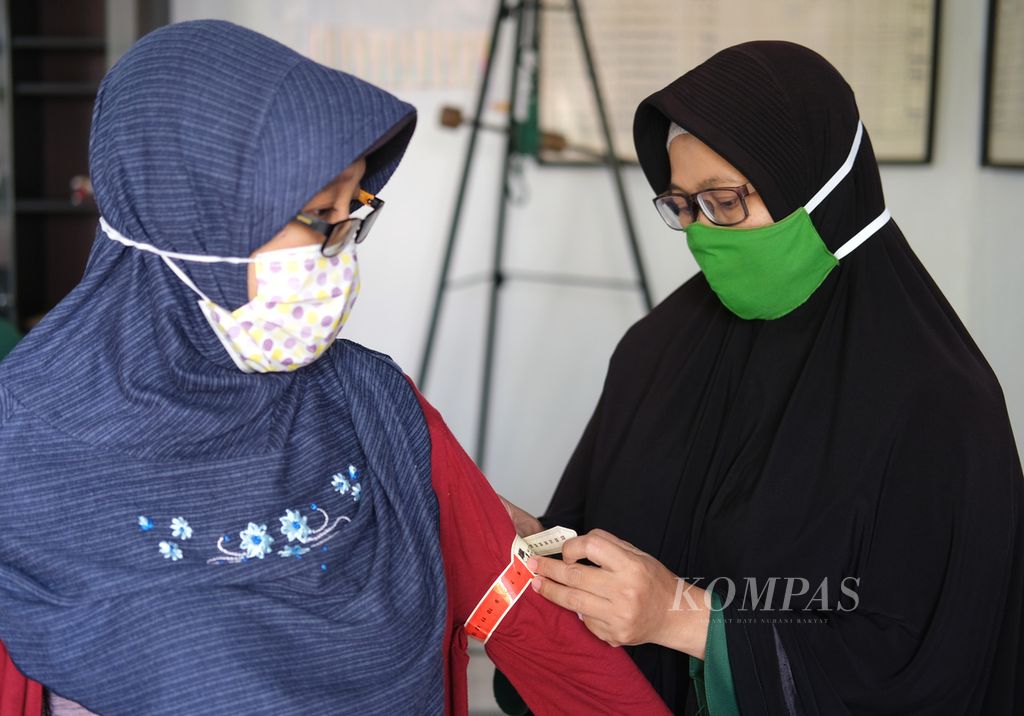 Kader posyandu mengukur lingkar lengan ibu hamil dalam kegiatan Posyandu Teratai, RW 015 Kelurahan Larangan Selatan, Larangan, Tangerang, Banten, Sabtu (18/7/2020). 